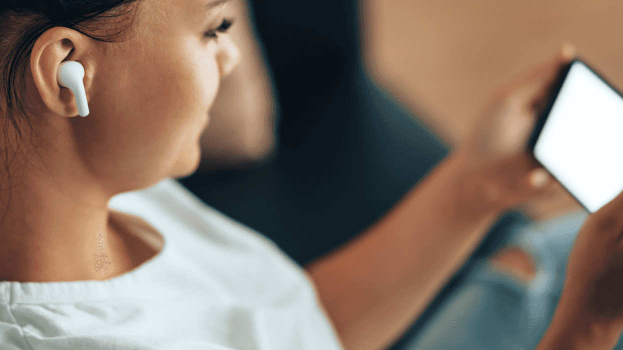 A woman wears wireless bluetooth headphones