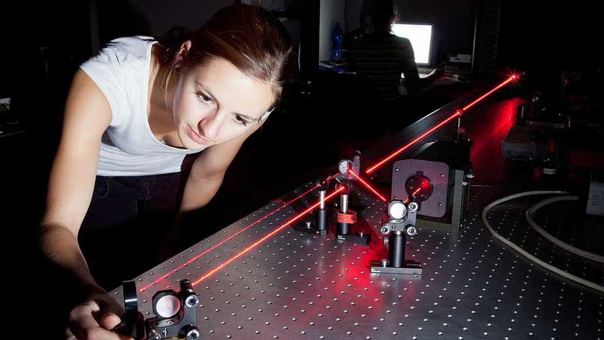 A woman working with a laser in a lab