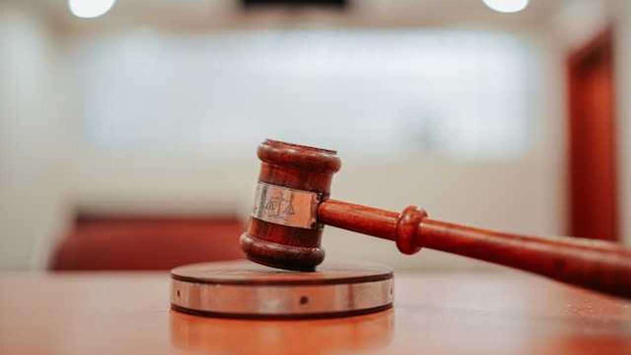 A wooden gavel resting on a round pedestal on top of a desk