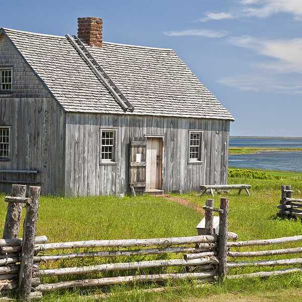 A wooden house with water in the background