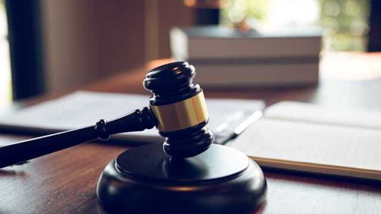 A wooden judge's gavel on a wooden desk