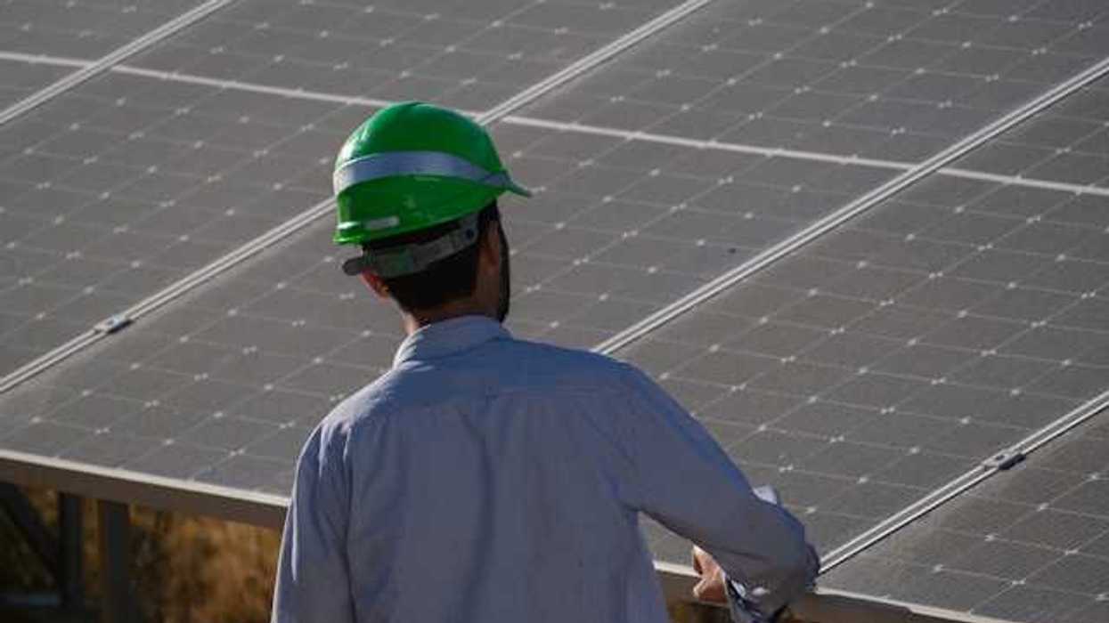 A worker inspecting a solar panel