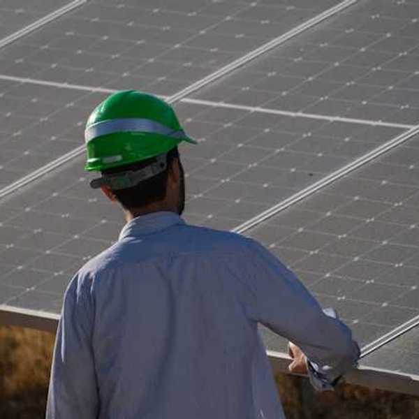 A worker inspecting a solar panel