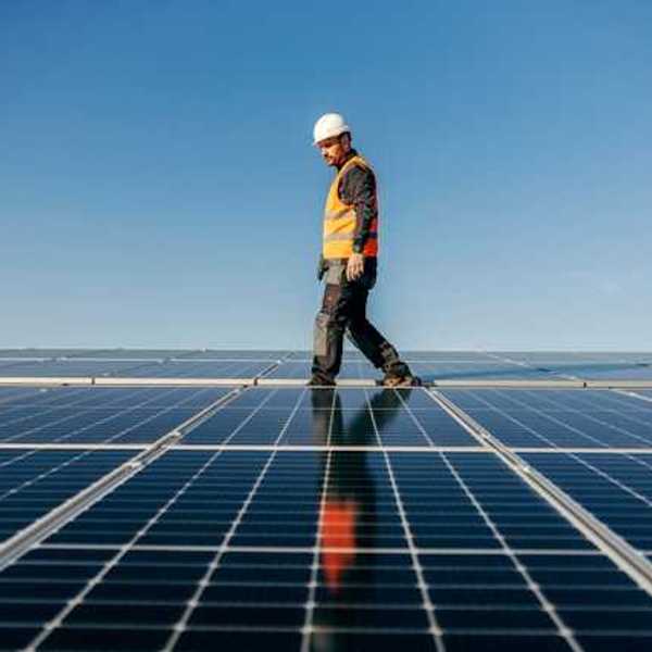 A worker walking among solar panels