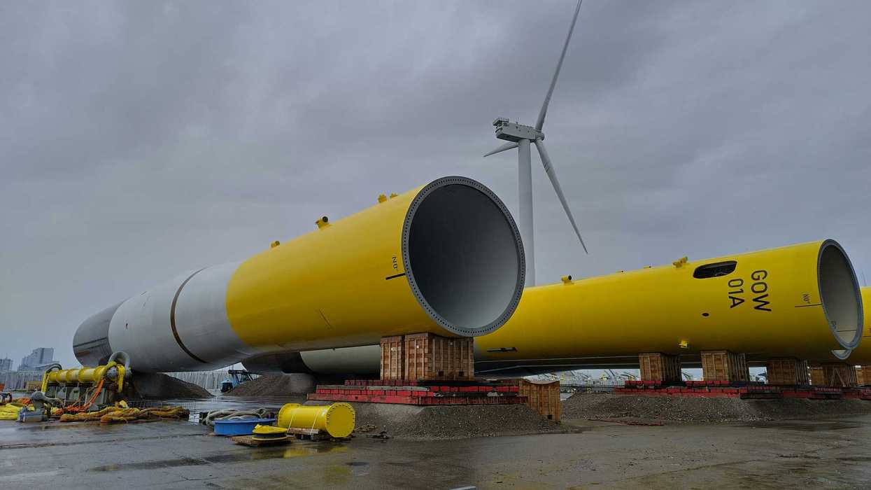 a yellow wind turbine sitting on top of a tarmac