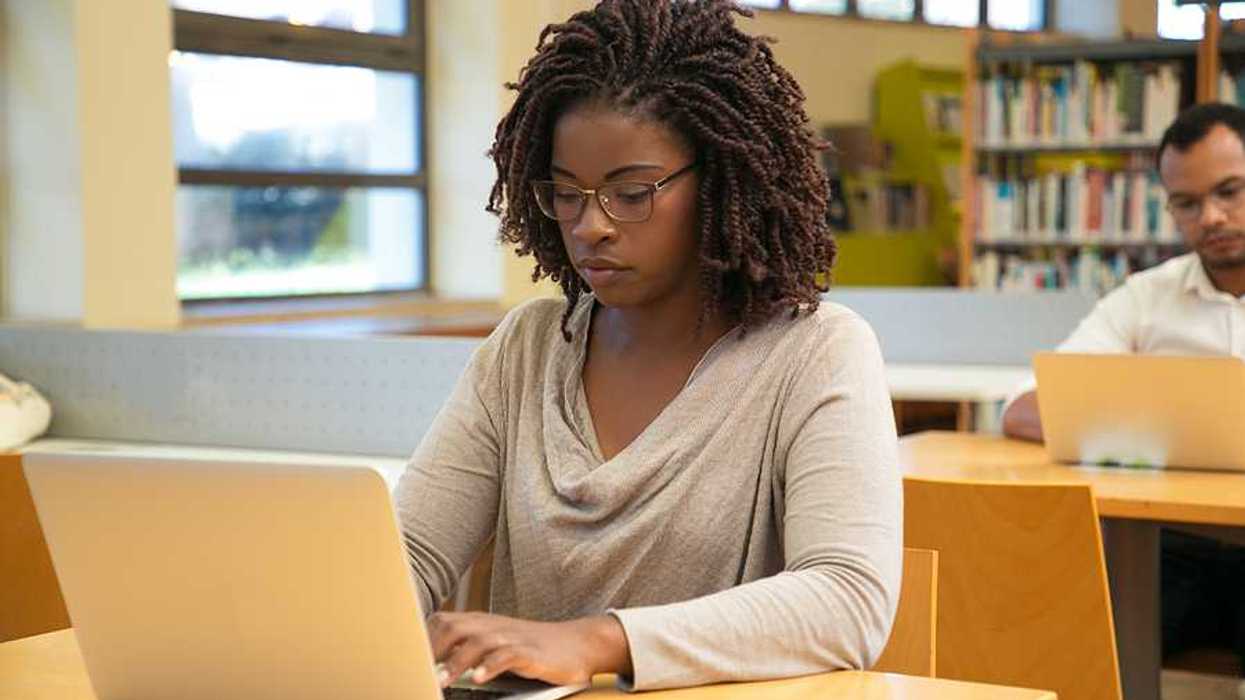 A young Black woman working on a computer