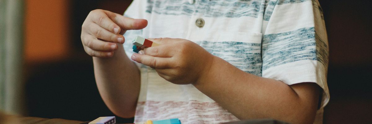A young boy plays with block toys