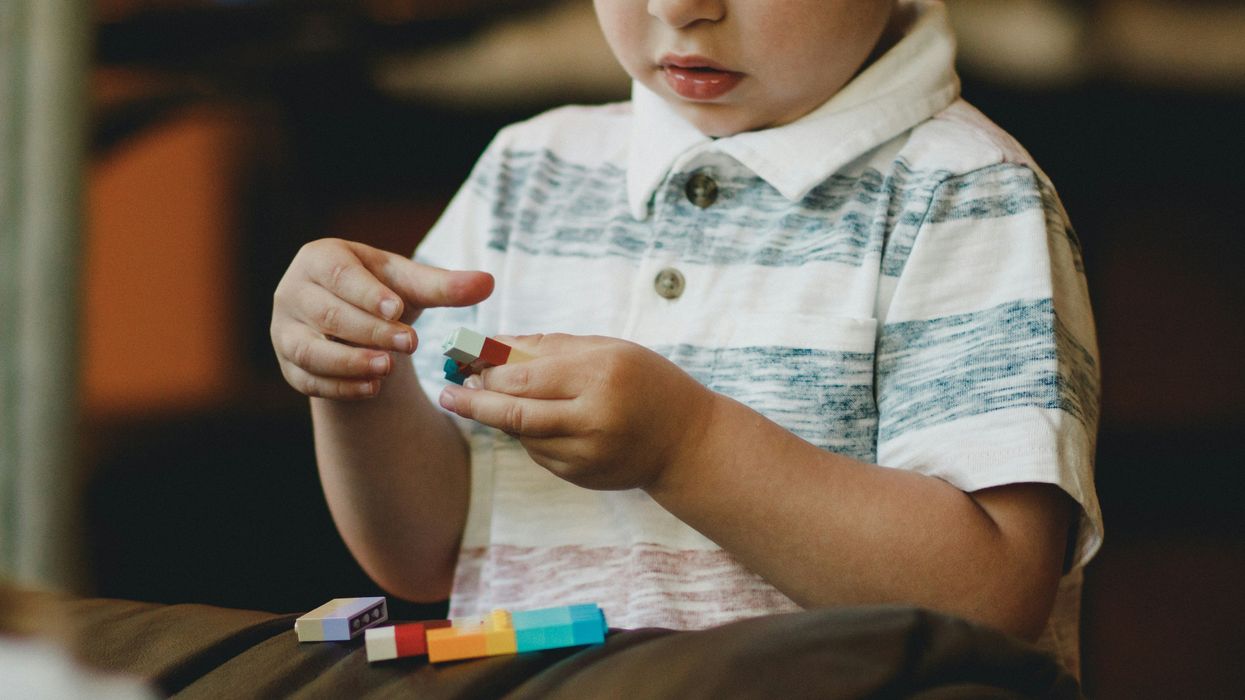 A young boy plays with block toys