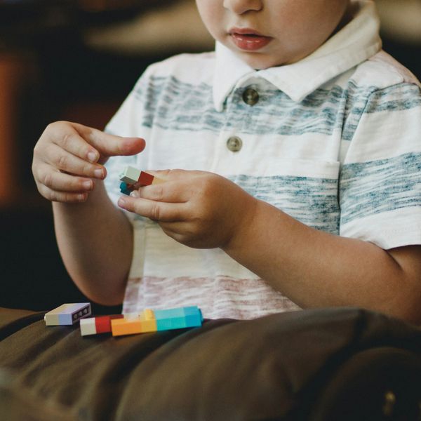 A young boy plays with block toys