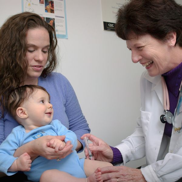 a young child being vaccinated by a doctor