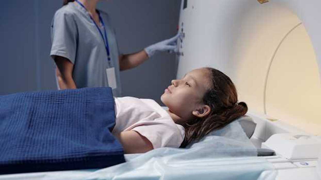 A young girl being placed into an xray machine