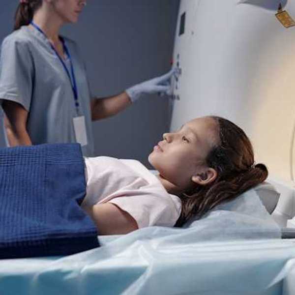 A young girl being placed into an xray machine