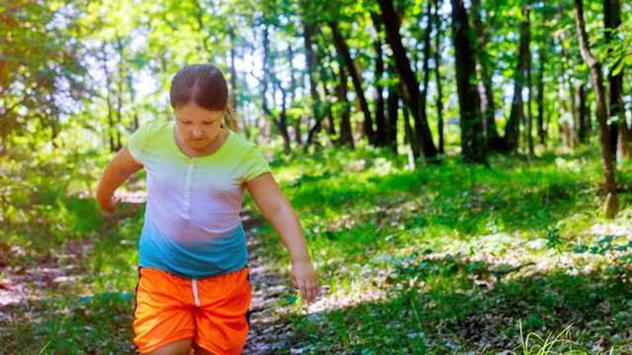 A young girl running through a forest