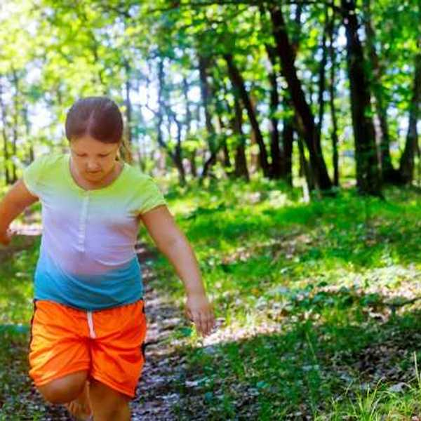 A young girl running through a forest