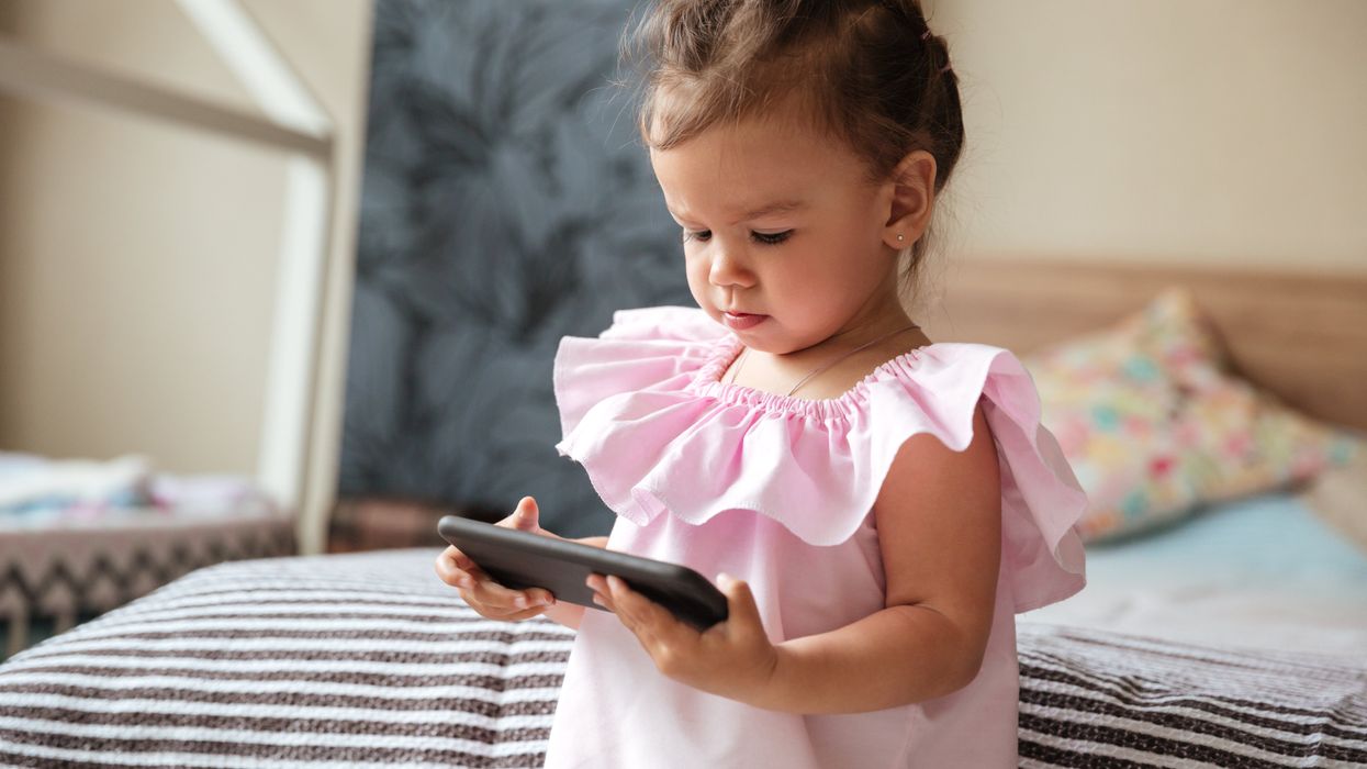 A young girl uses a cell phone