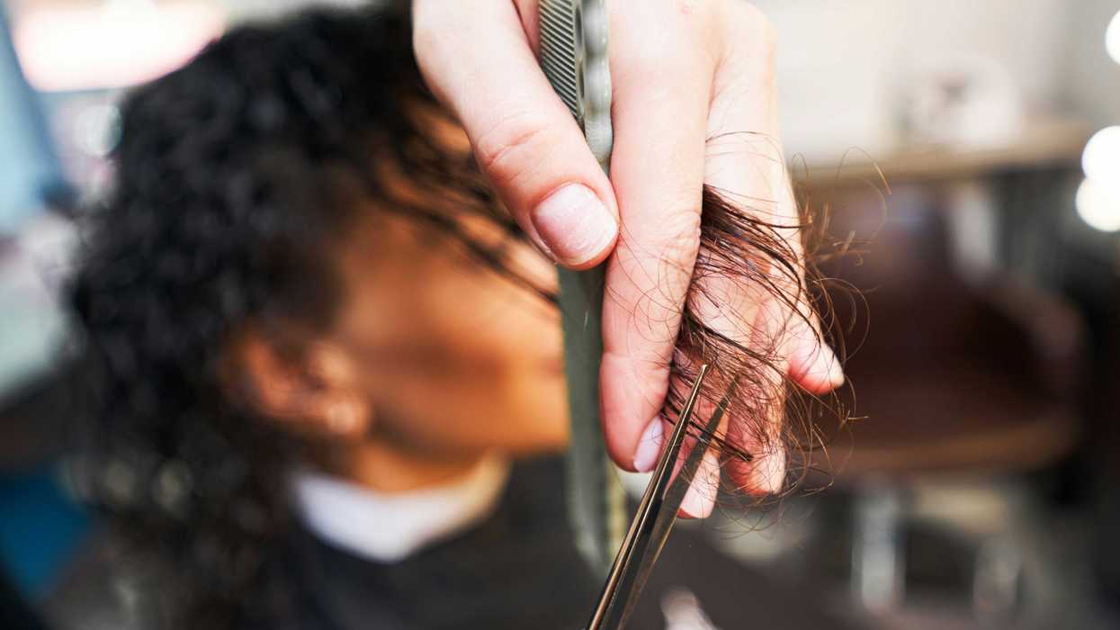 A young woman gets her hair cut at a salon