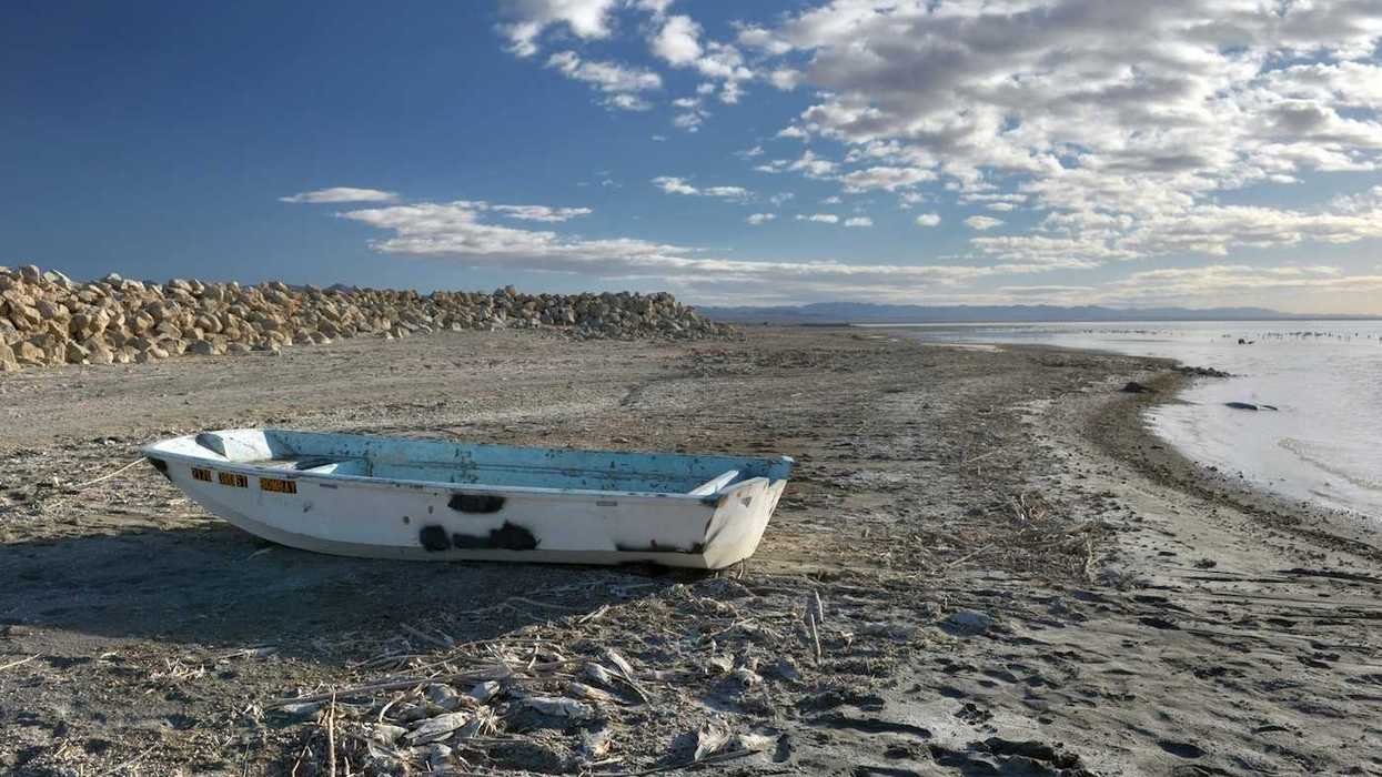 Abandoned derelict rowboat beached on the shore of the Salton Sea