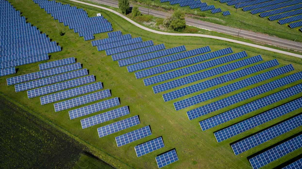 aerial photography of grass field with blue solar panels.