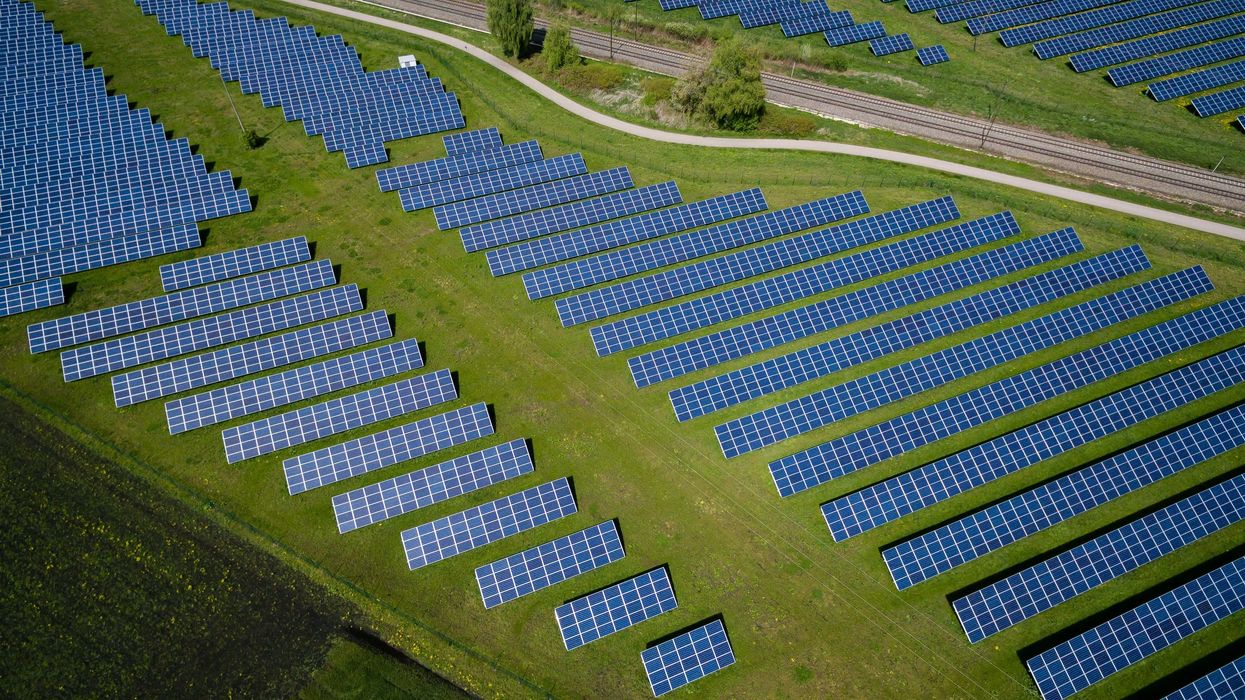 aerial photography of grass field with vast rows of solar panels.