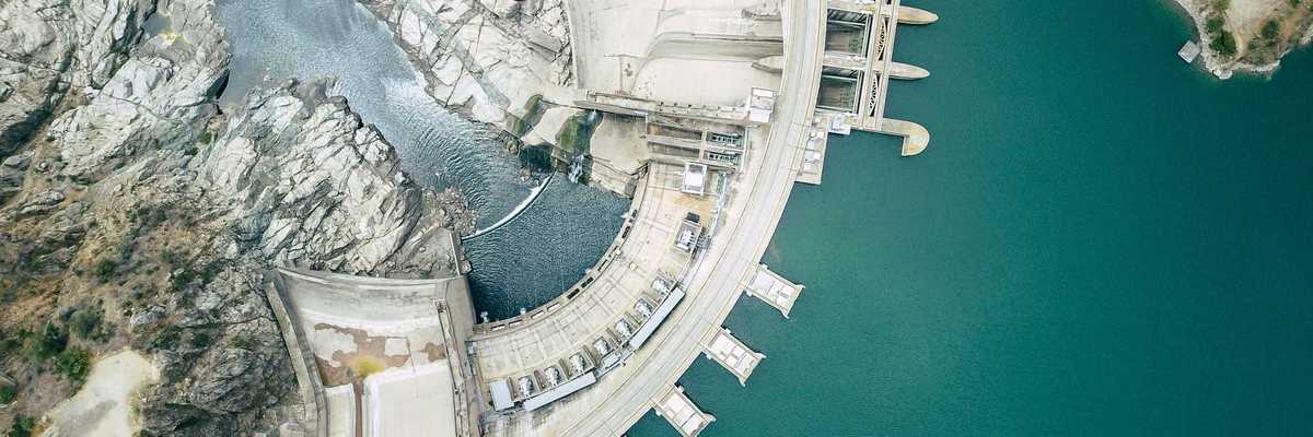 Aerial view of a dam with blue green water.