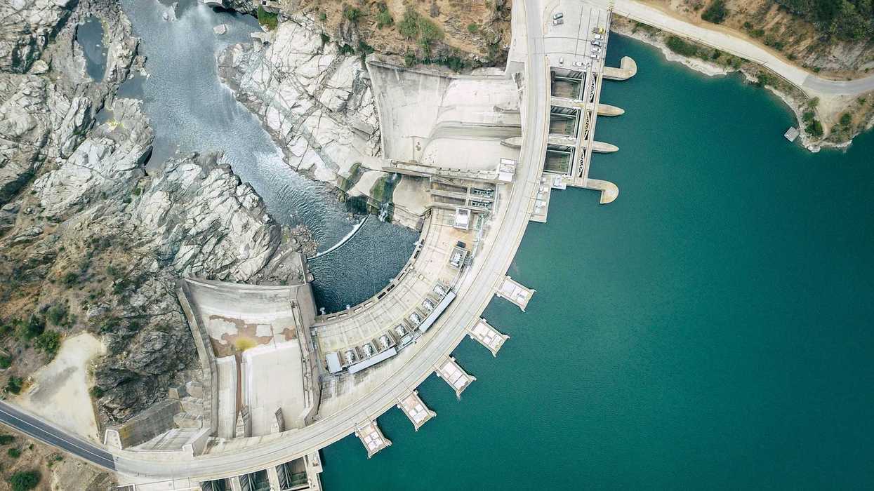 Aerial view of a dam with blue green water.