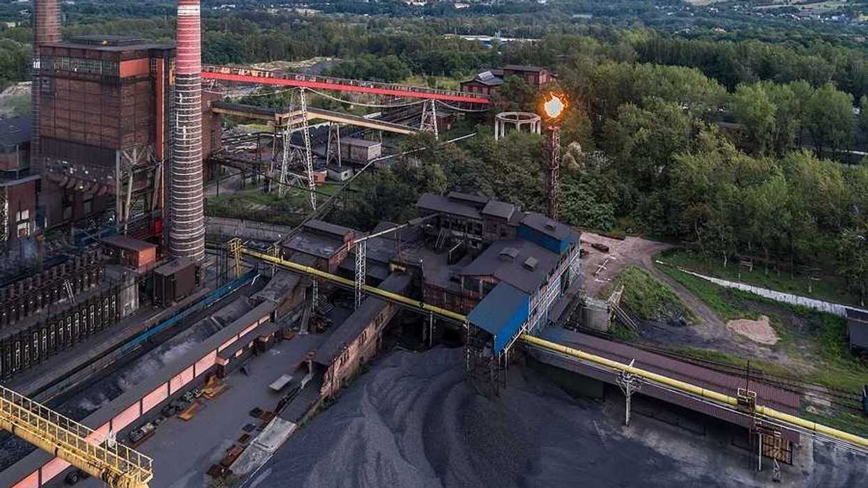 Aerial view on old working coking plant. Smokestacks, coal waste, flaring in progress.