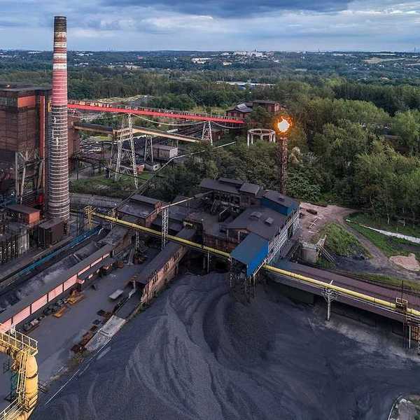 Aerial view on old working coking plant. Smokestacks, coal waste, flaring in progress.