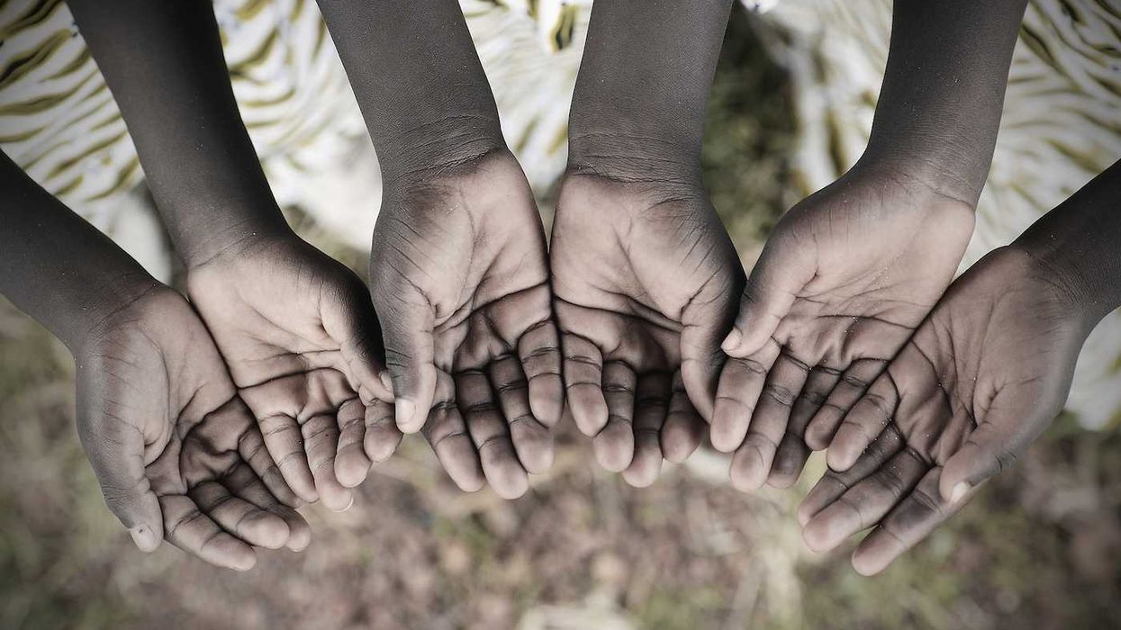 African children keeping their cupped hands asking for help.