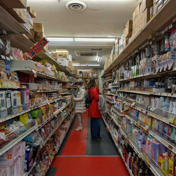 Aisle of a well-stocked retail store with many products.