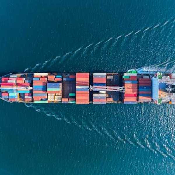An aerial view of a boat on the ocean with colorful cargo