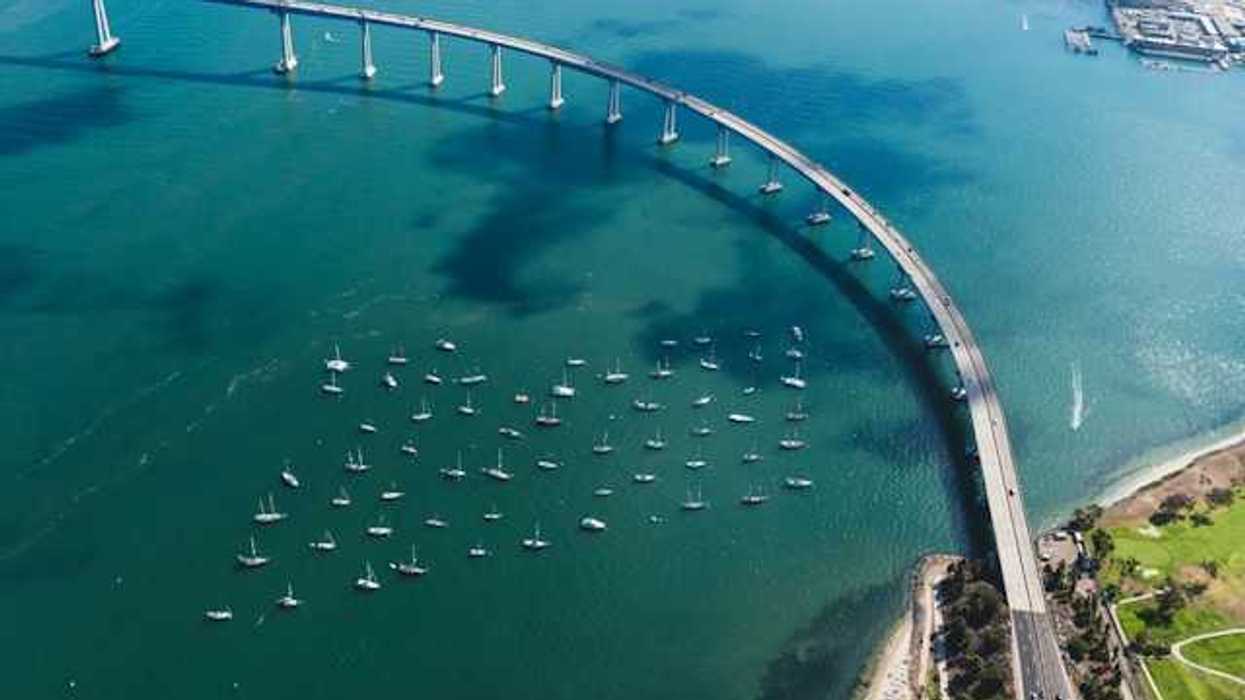 An aerial view of a body of water with a bridge crossing it