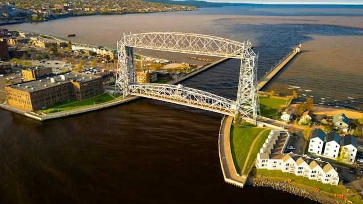 An aerial view of a bridge and channel opening into a large lake