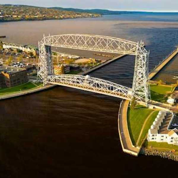 An aerial view of a bridge and channel opening into a large lake