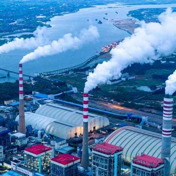 An aerial view of a chemical plant with smoke spewing from smokestacks