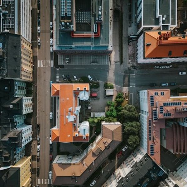 An aerial view of a city street with green trees