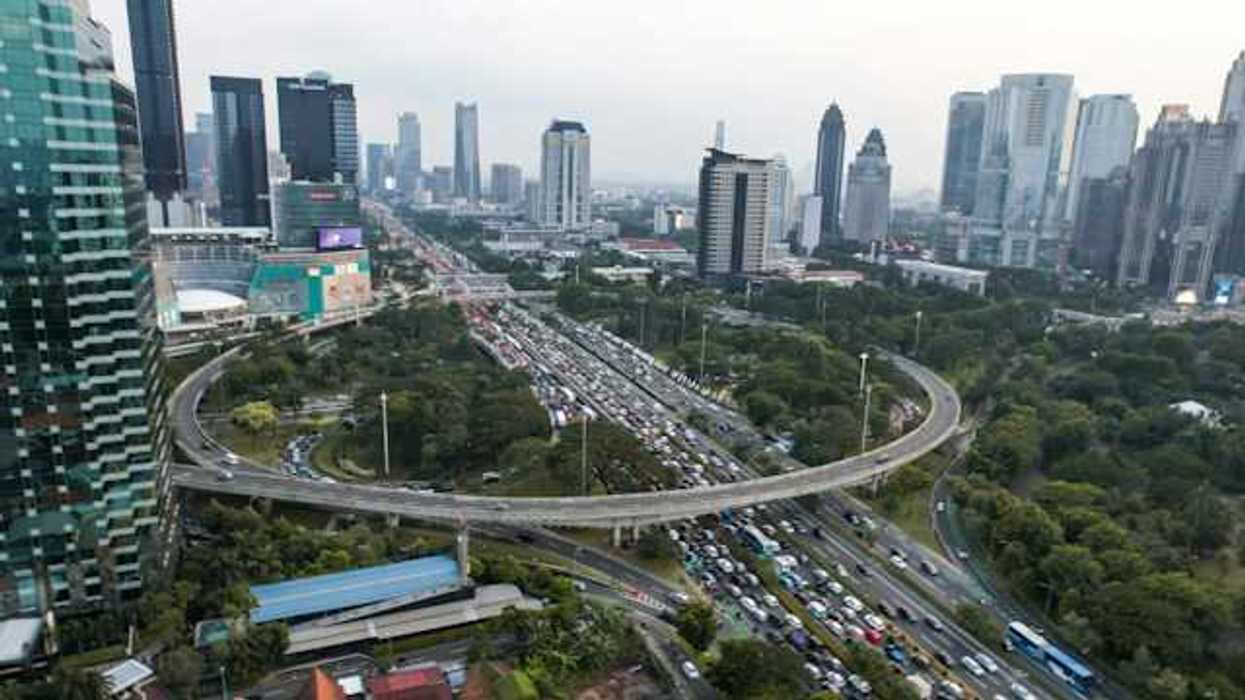 An aerial view of a city with a busy freeway cutting through it