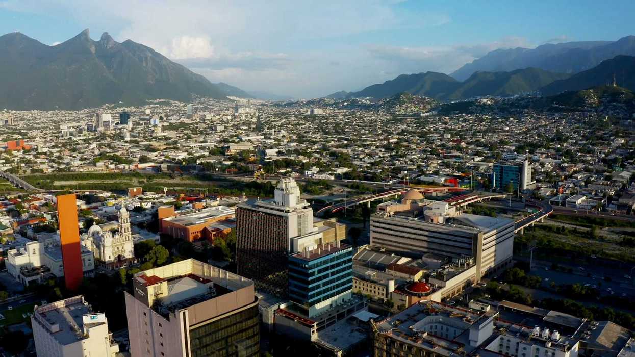 an aerial view of a city with mountains in the background.