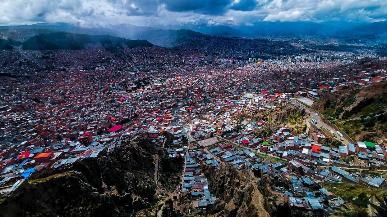 an aerial view of a city with mountains in the background.