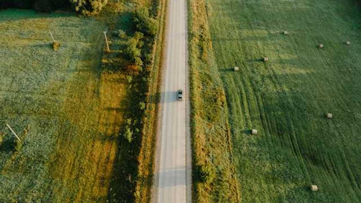 An aerial view of a highway between green fields