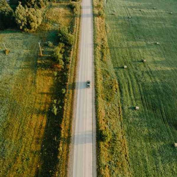 An aerial view of a highway between green fields