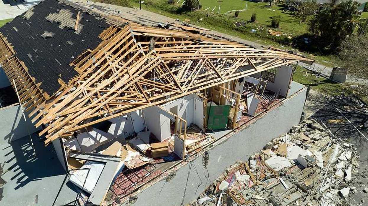 An aerial view of a home that has been damaged by a hurricane