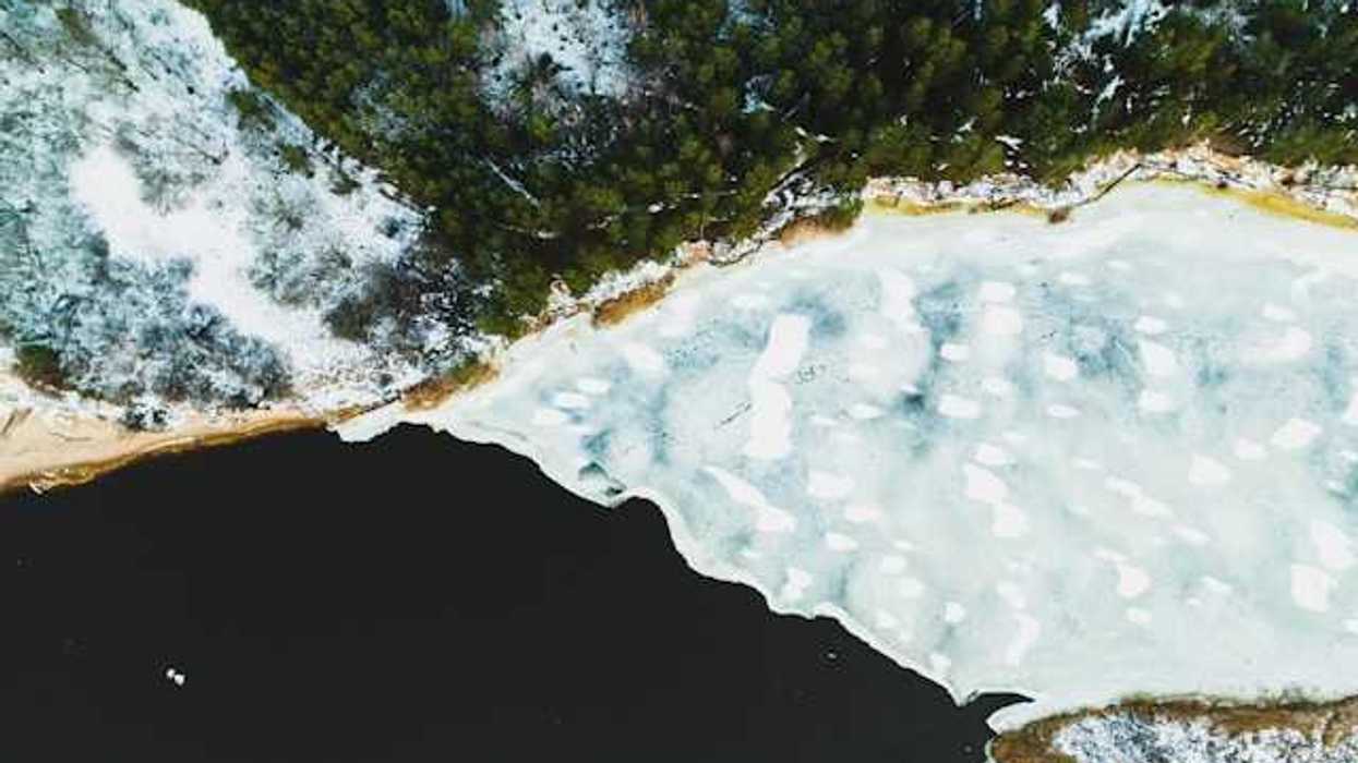 An aerial view of a lake covered in snow and ice