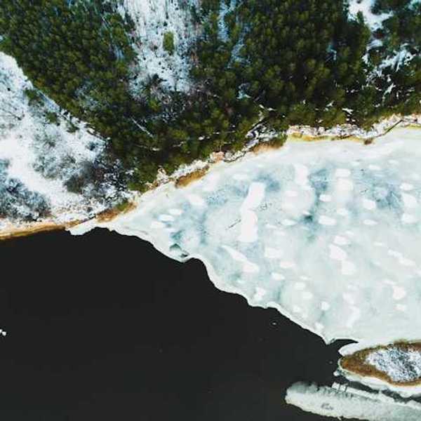 An aerial view of a lake covered in snow and ice
