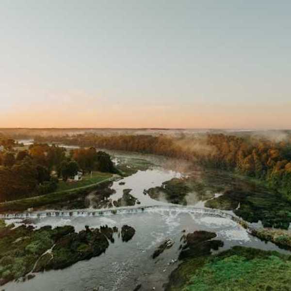An aerial view of a river with bushes and trees lining it