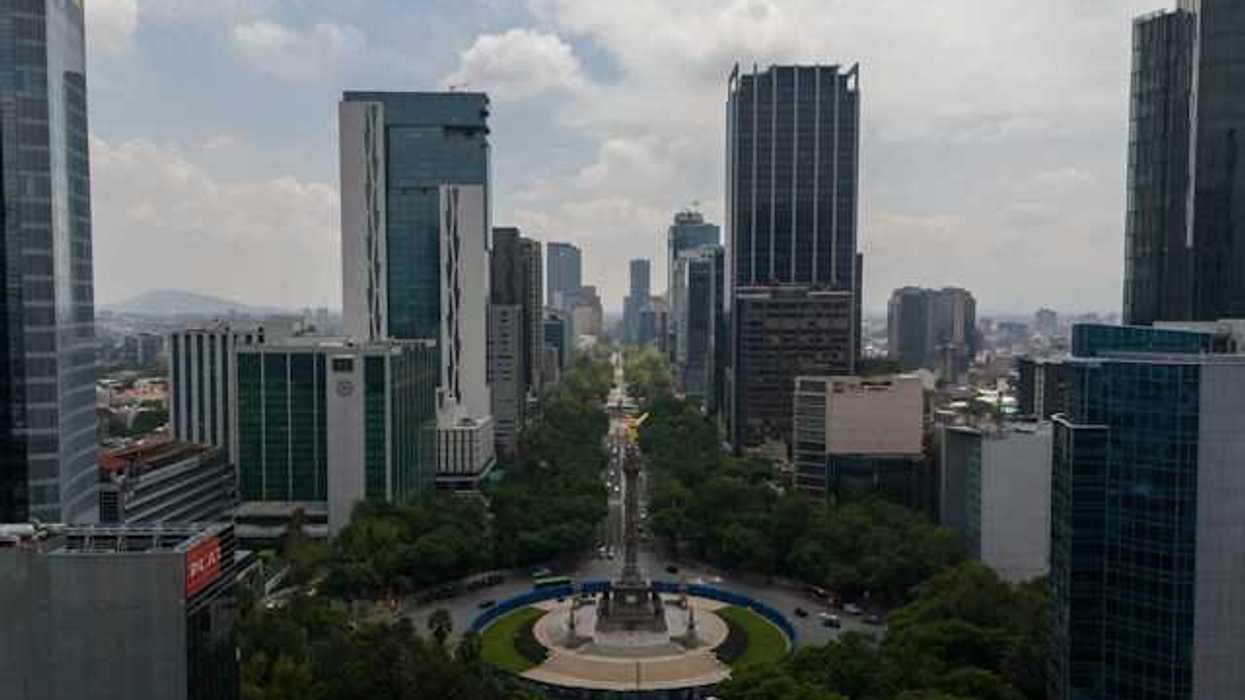 An aerial view of a roundabout with tall city buildings in the background