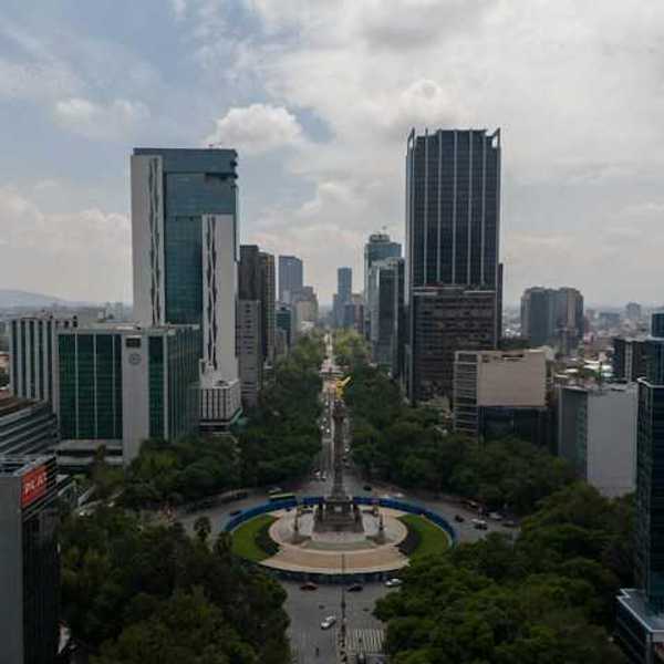 An aerial view of a roundabout with tall city buildings in the background