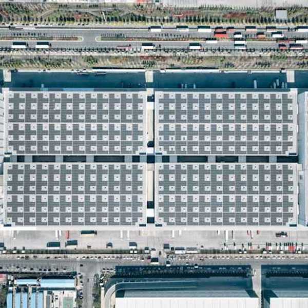 An aerial view of a warehouse complex with a road to one side