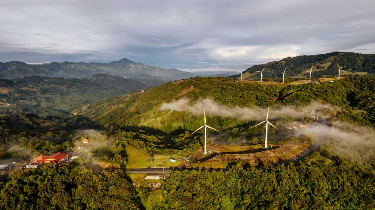 an aerial view of a wind farm in the mountains.