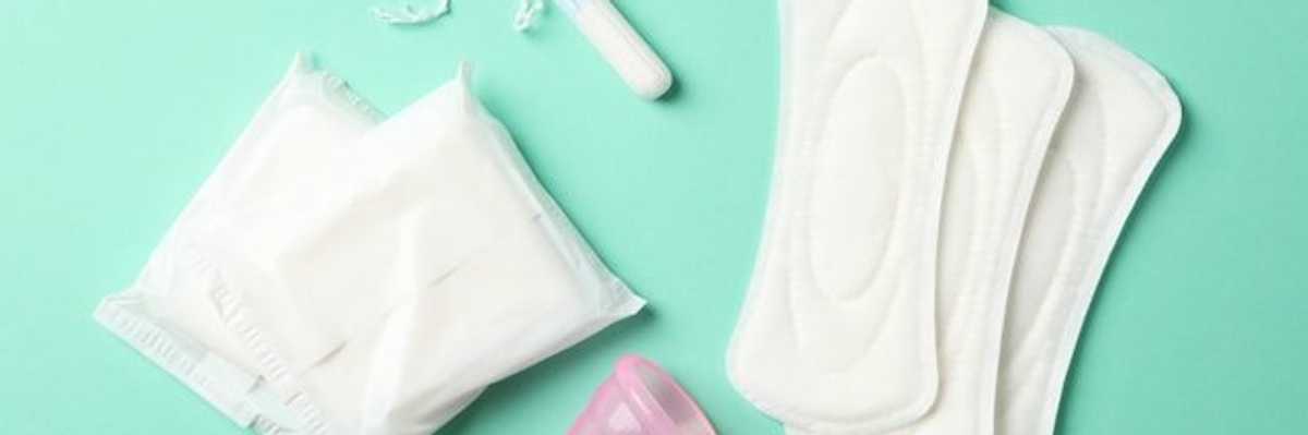 An assortment of menstrual products on a green surface.