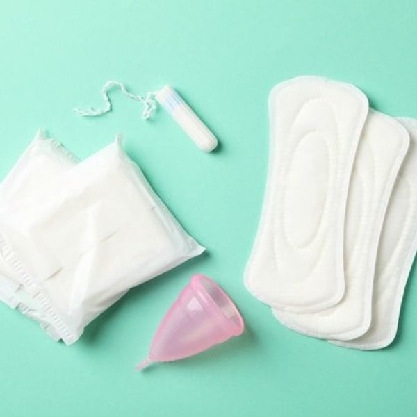 An assortment of menstrual products on a green surface.
